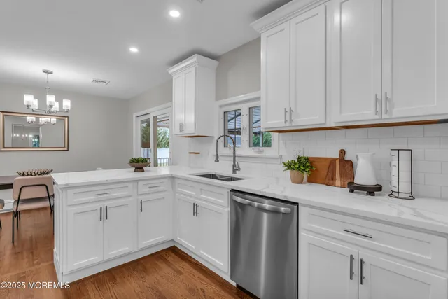 a kitchen with a sink white cabinets and white appliances