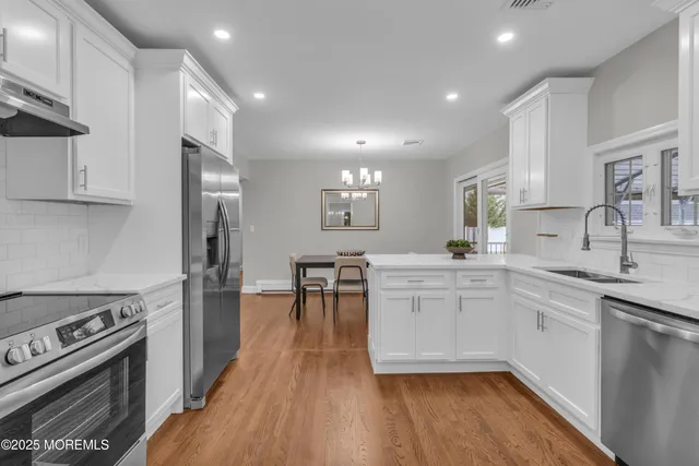 a kitchen with white cabinets stove and sink