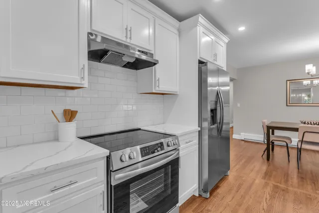 a kitchen with stainless steel appliances a stove a refrigerator and wooden cabinets