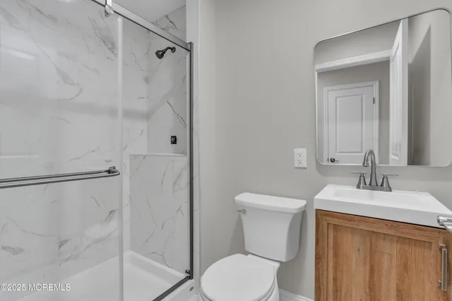 a bathroom with a sink vanity mirror and toilet