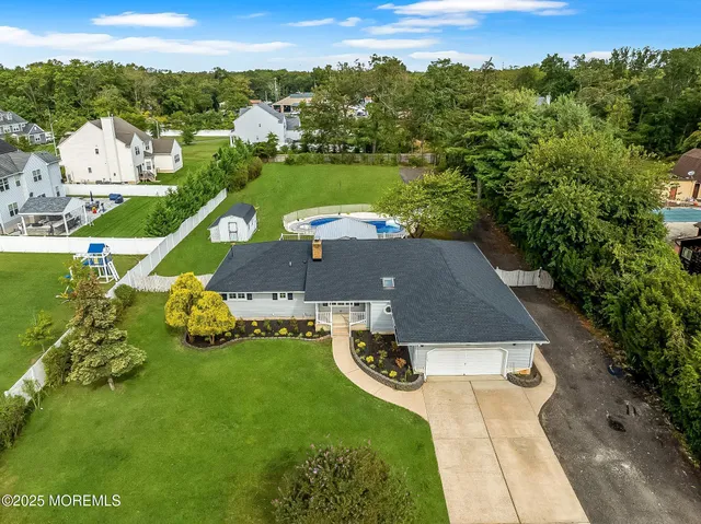 an aerial view of a house with swimming pool big yard and mountain view in back