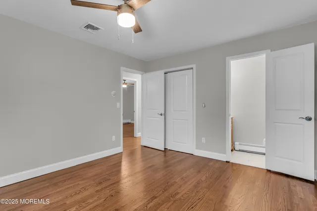 a view of an empty room with wooden floor