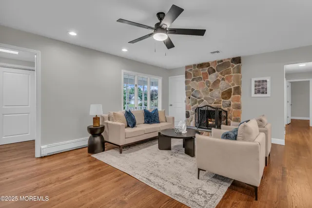 a living room with furniture a fireplace and a ceiling fan