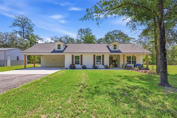 a front view of house with yard and outdoor seating