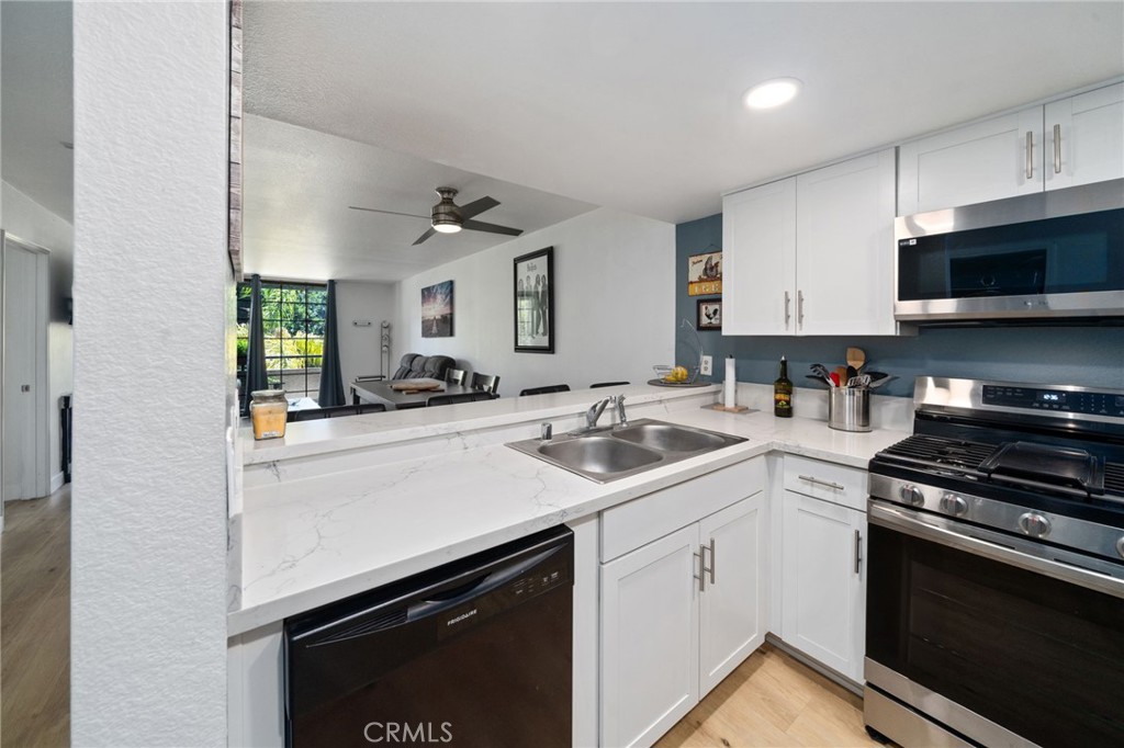 1237 East 6th Street, Unit 201 Long Beach, CA 90802 - Photo 4 of 27 a kitchen with a sink stove and cabinets