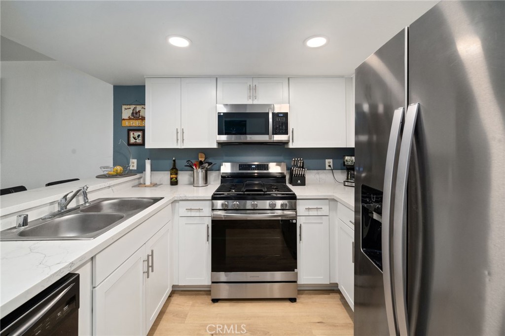 1237 East 6th Street, Unit 201 Long Beach, CA 90802 - Photo 5 of 27 a kitchen with a stove sink and refrigerator