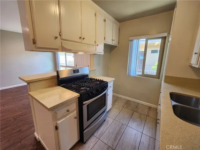 a kitchen with granite countertop a stove and white cabinets