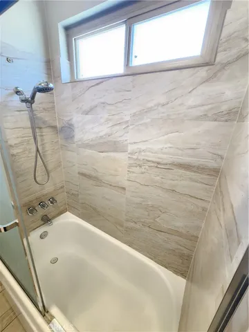 a bathroom with a bathtub and shower