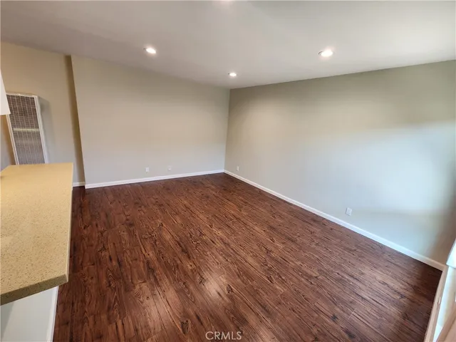 an empty room with wooden floor and entrance