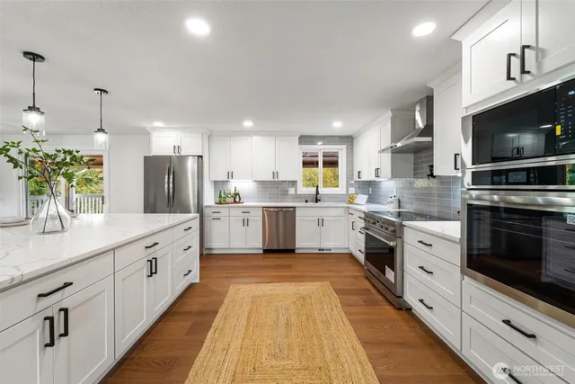 a kitchen with kitchen island granite countertop a sink cabinets and wooden floor