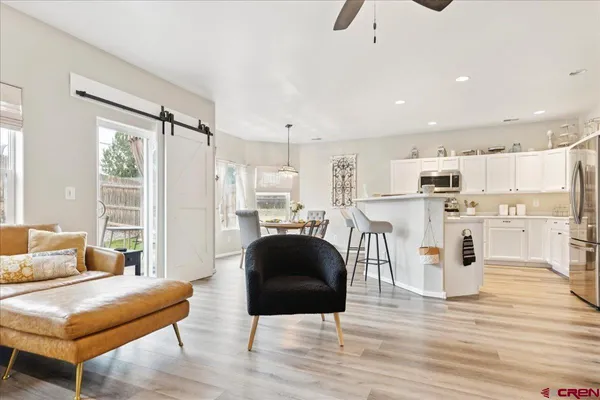 a living room with stainless steel appliances kitchen island granite countertop a refrigerator and a fireplace