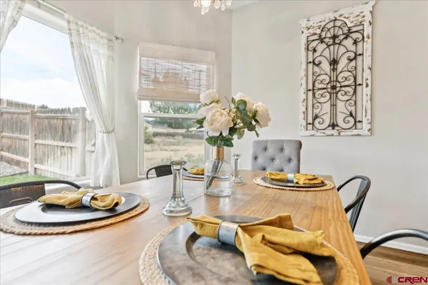 a dining room with wooden floor table and chairs