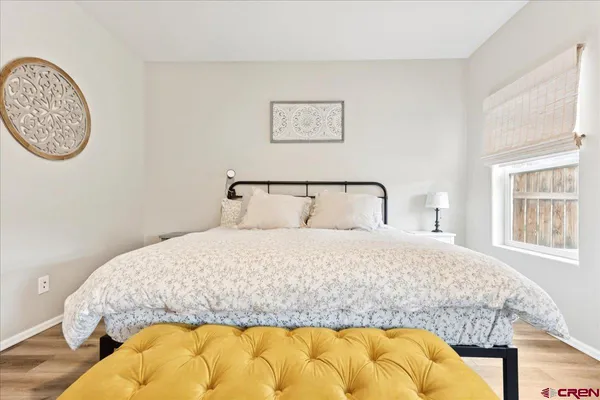 a bedroom with a bed and a painting on the wall
