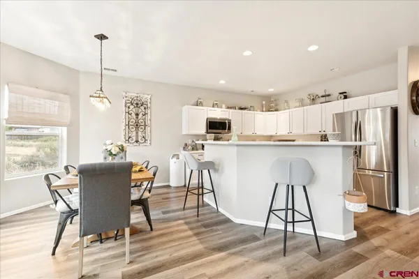a dining room filled a chandelier a glass table and chairs