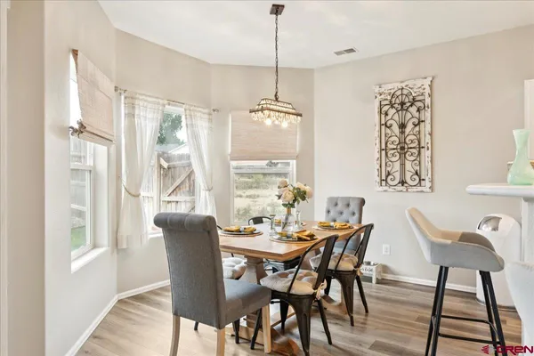 a dining room with furniture a chandelier and wooden floor