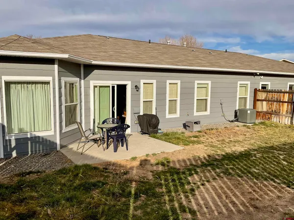 a view of a house with backyard and sitting area