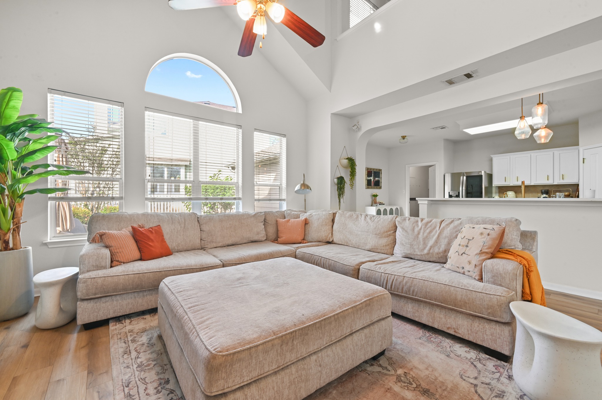 5888 Fergus Kyle, TX 78640 - Photo 5 of 40 A spacious living room features soaring vaulted ceilings and abundant natural light from a series of tall windows.