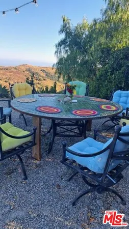 a view of a backyard with table and chairs