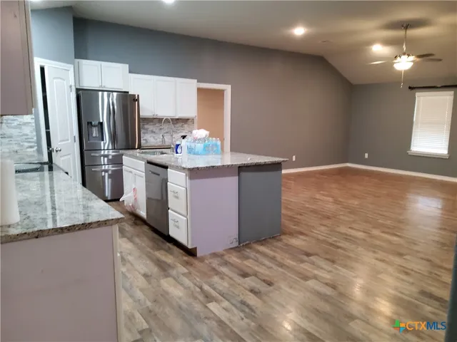 a bathroom with a granite countertop toilet and a sink