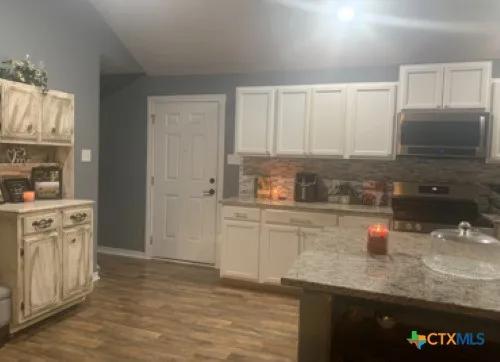 a kitchen with stainless steel appliances granite countertop a sink stove and cabinets