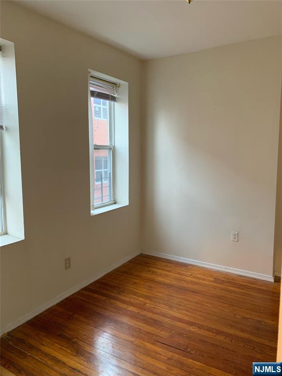 5616 Hudson Avenue, Unit 1D West New York, NJ 07093 - Photo 6 of 11 a view of an empty room with wooden floor and a window