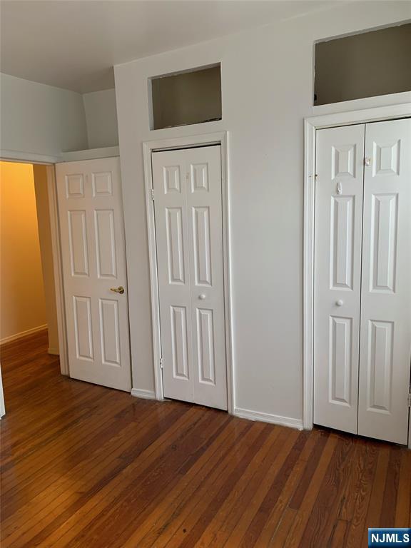 5616 Hudson Avenue, Unit 1D West New York, NJ 07093 - Photo 7 of 11 an empty room with wooden floor and windows