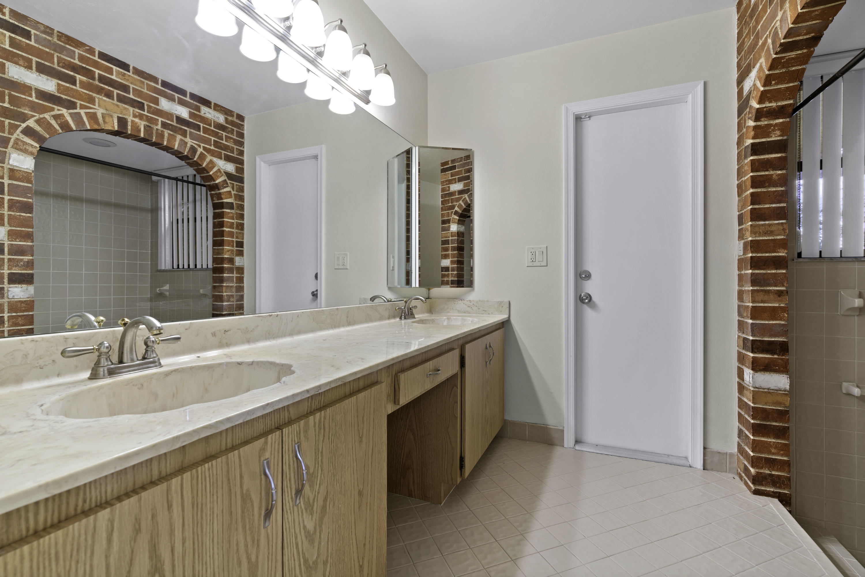 3375 Northwest 27th Avenue Boca Raton, FL 33434 - Photo 11 of 27 a bathroom with a double vanity sink and a mirror