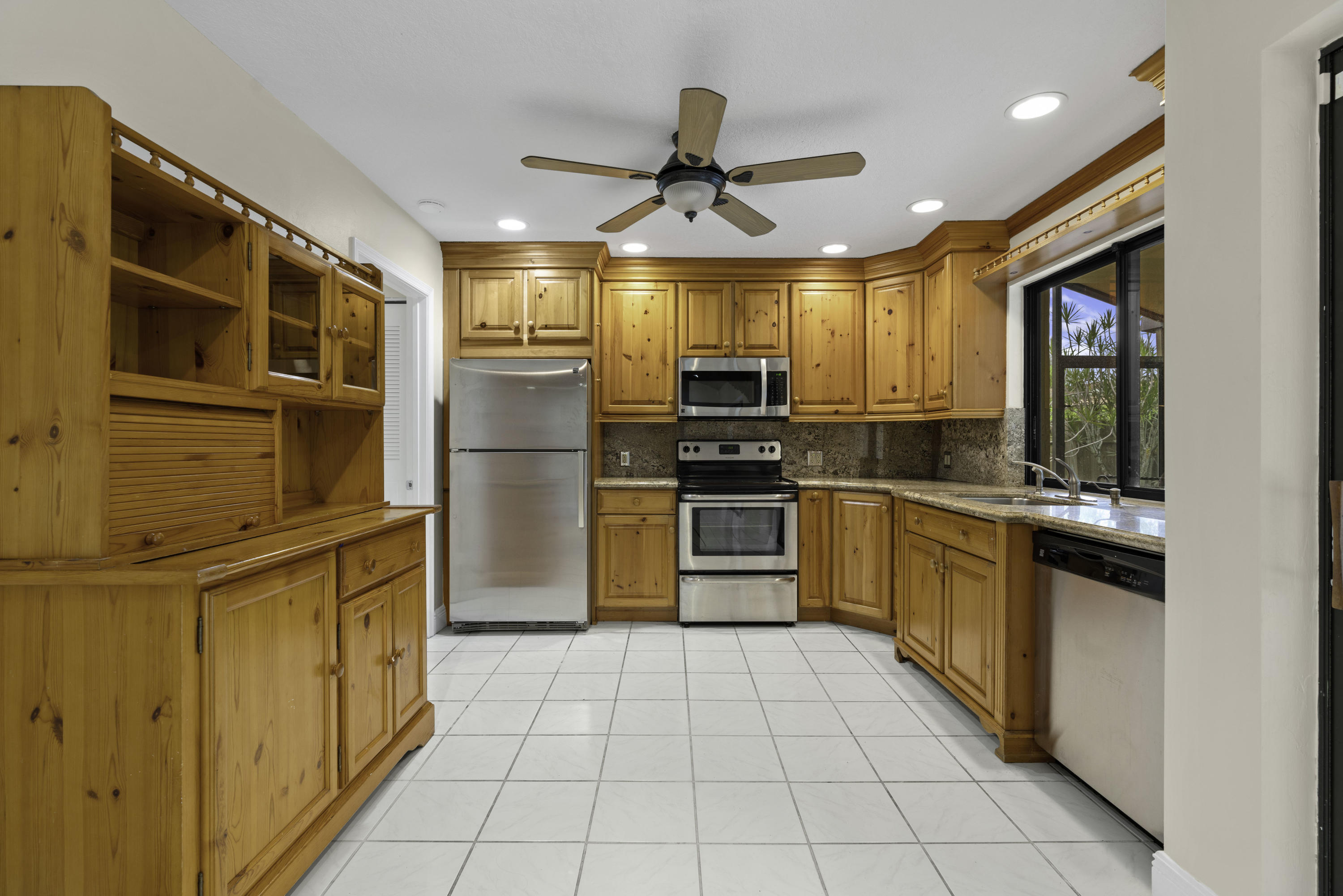 3375 Northwest 27th Avenue Boca Raton, FL 33434 - Photo 4 of 27 a kitchen with stainless steel appliances granite countertop a refrigerator and a stove top oven