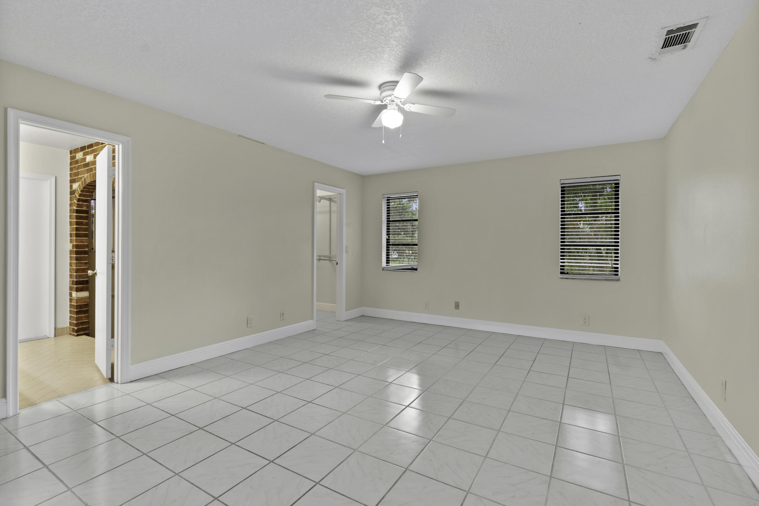 3375 Northwest 27th Avenue Boca Raton, FL 33434 - Photo 10 of 27 an empty room with windows and fan
