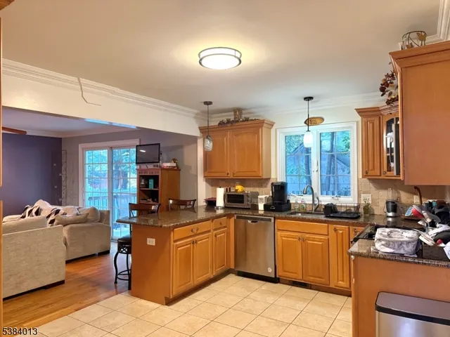 a kitchen with a sink a counter top space and living room view