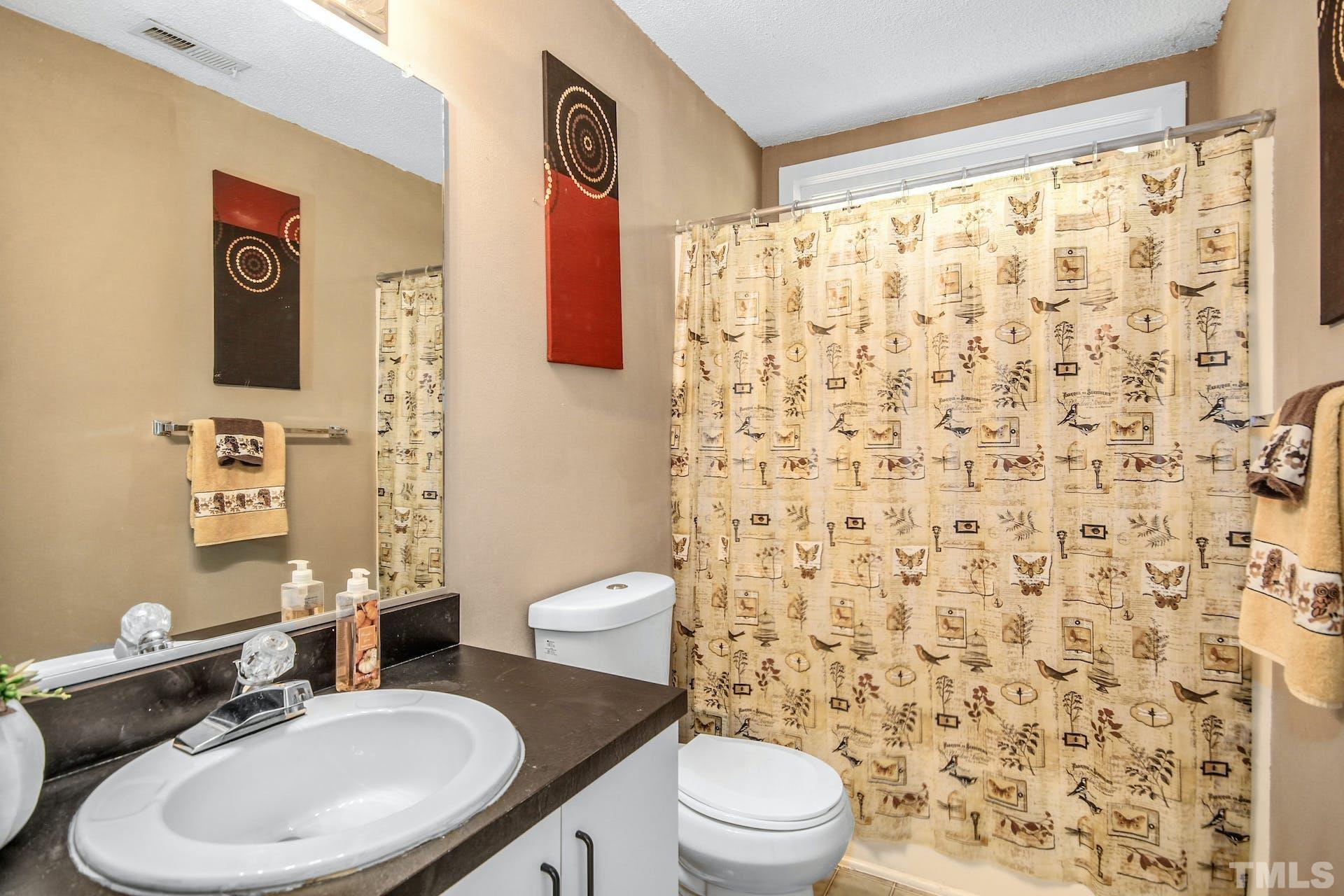 4605 Batavia Court Raleigh, NC 27604 - Photo 12 of 18 a bathroom with a toilet sink and mirror