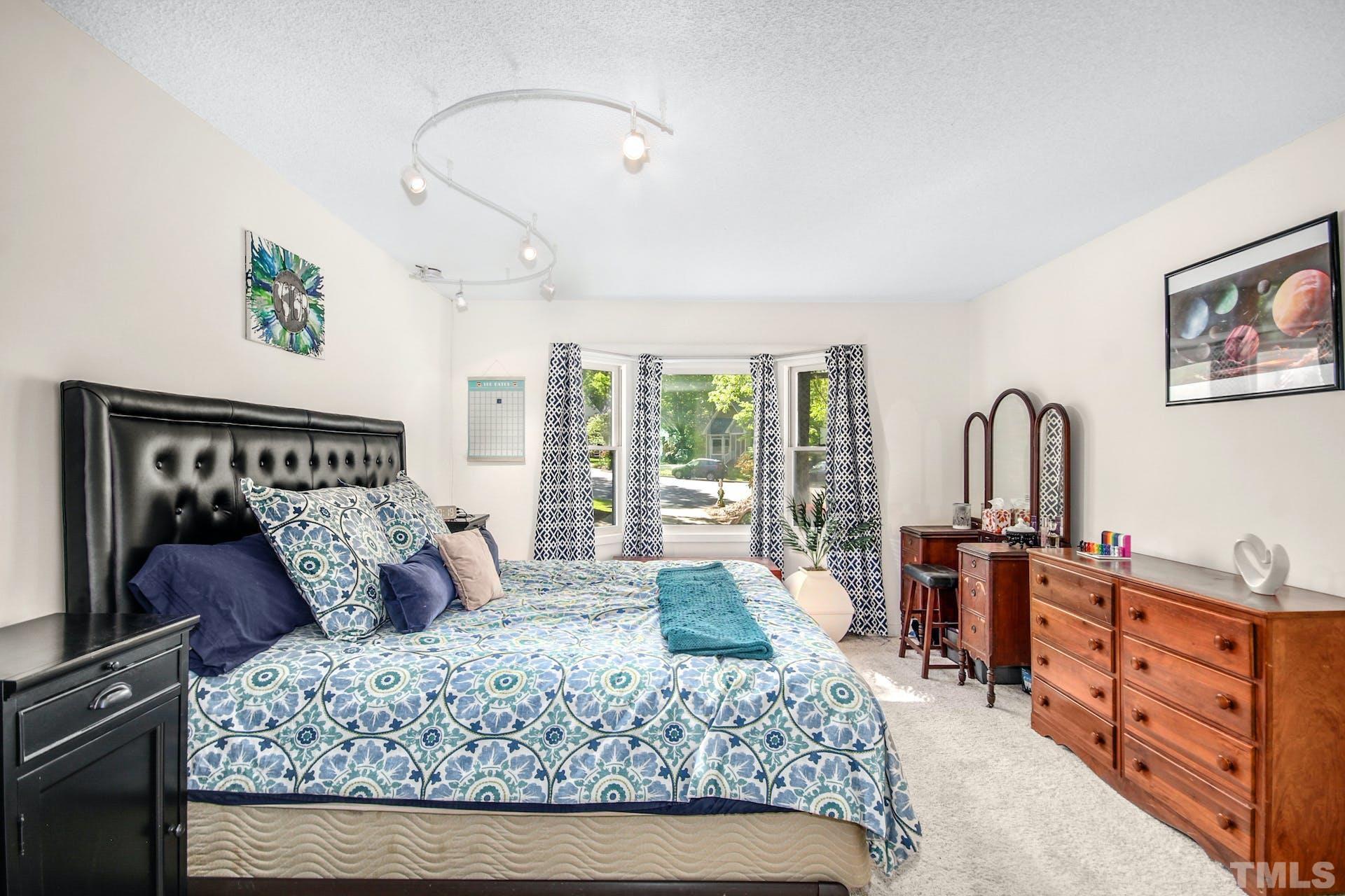 4605 Batavia Court Raleigh, NC 27604 - Photo 10 of 18 a bedroom with a large bed and a dresser