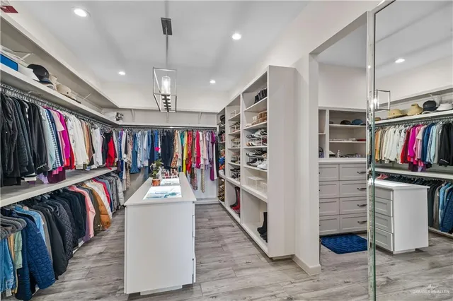 a view of walk in closet with clothes and shoes