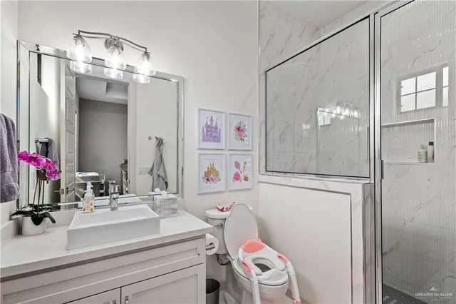 a bathroom with a sink a toilet and shower