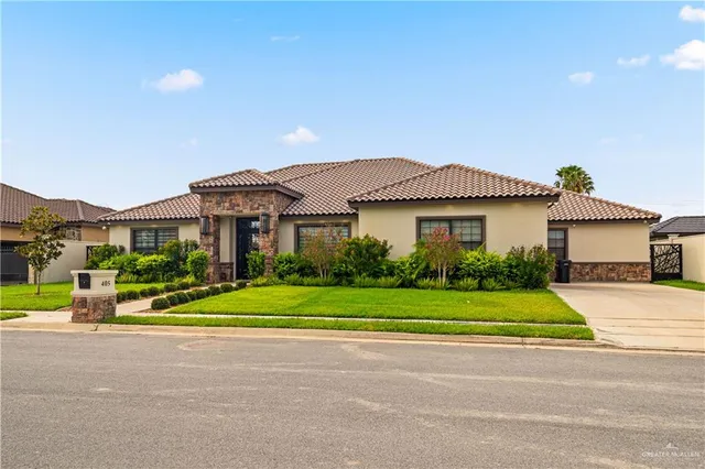 a front view of a house with a yard and trees
