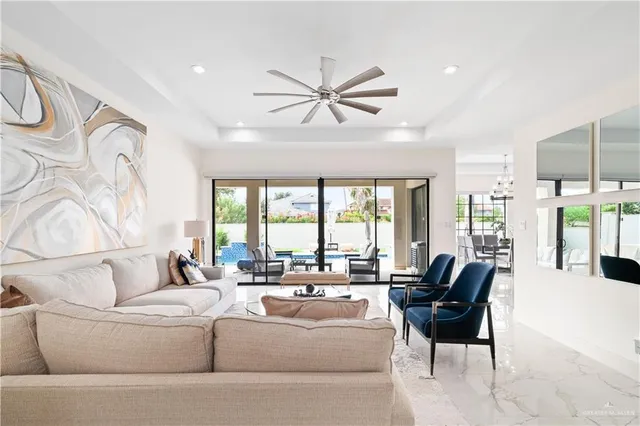a living room with furniture a chandelier and a potted plant