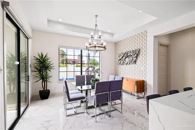 a kitchen with stainless steel appliances kitchen island granite countertop a sink a stove a refrigerator and white cabinets