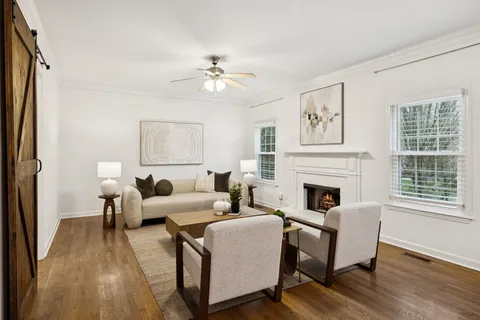 a living room with furniture two windows and a fireplace