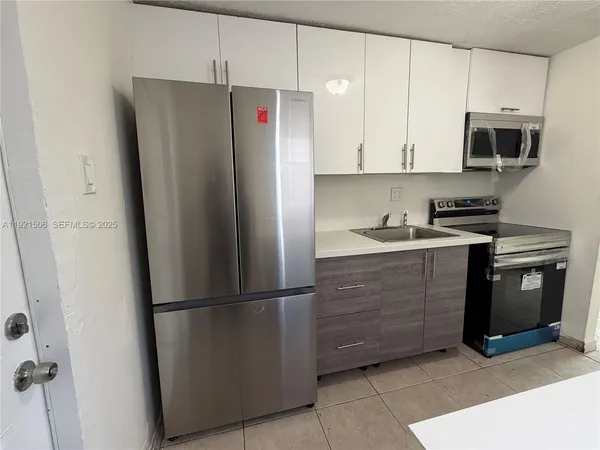 a kitchen with stainless steel appliances granite countertop a refrigerator a microwave a sink and cabinets