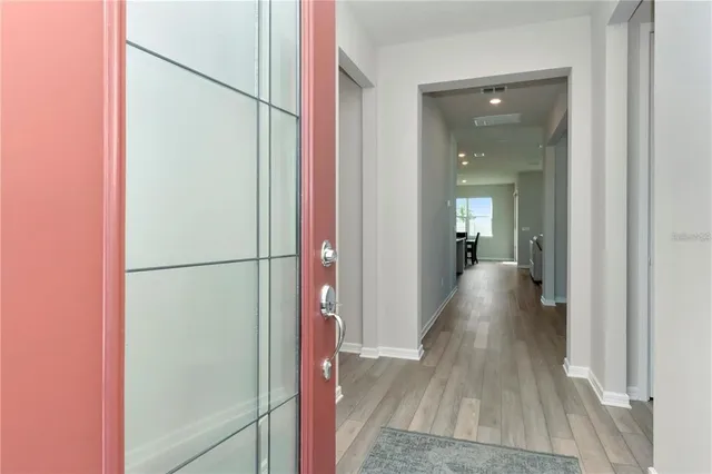 a view of a hallway with wooden floor