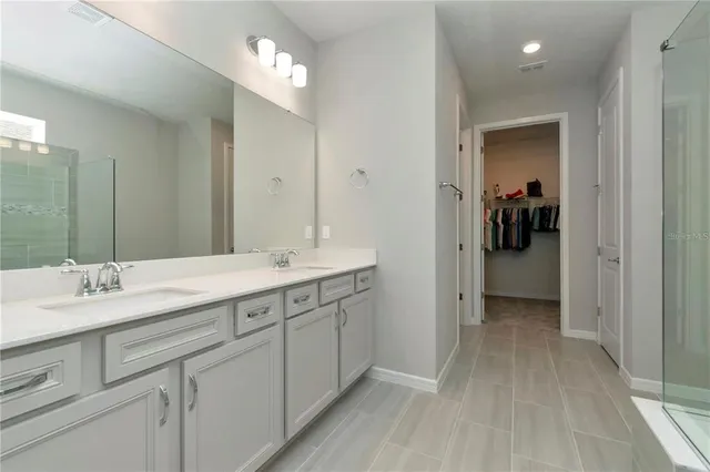 a bathroom with a double vanity sink and a mirror