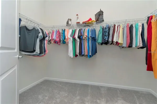 a view of walk in closet with clothes