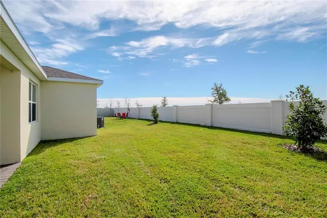 a view of a house with a big yard and large tree