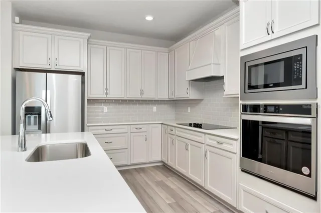 a kitchen with cabinets stainless steel appliances and sink