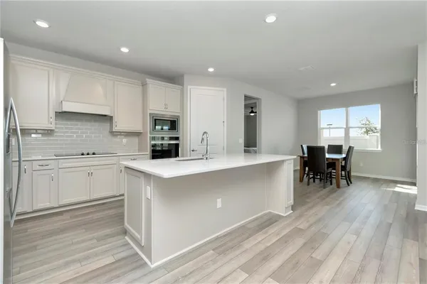 a kitchen with microwave a stove and white cabinets