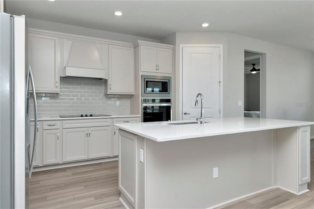1991 Spring Shower Circle Kissimmee, FL 34744 - Photo 10 of 51 a kitchen with kitchen island white cabinets and refrigerator