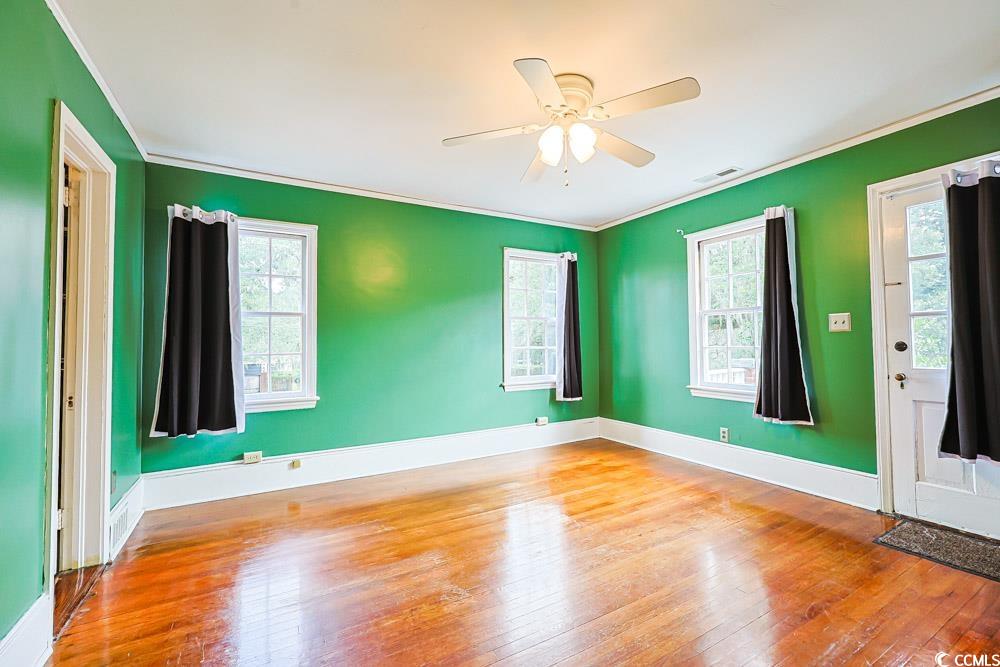 509 Beaty Street Conway, SC 29526 - Photo 22 of 40 Empty room with ornamental molding, wood-type flooring, and ceiling fan
