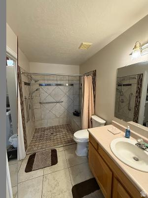 641 East Greystone Way Tooele, UT 84074 - Photo 9 of 30 Bathroom featuring a tiled shower with grab bars and a glass enclosure