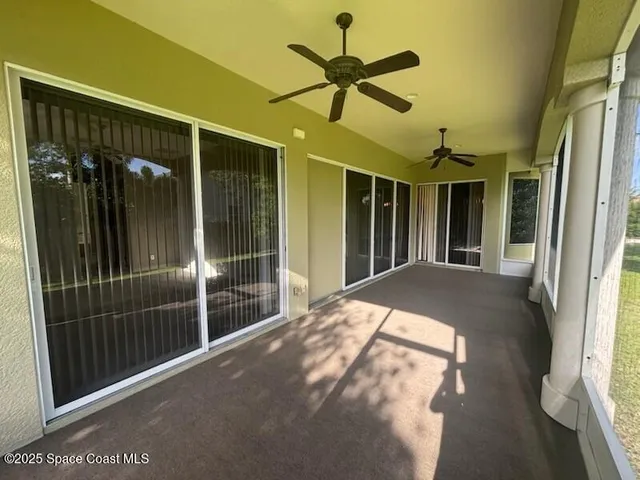 a bed room with balcony and a ceiling fan