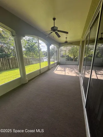 a view of a livingroom with an empty space and a floor to ceiling window